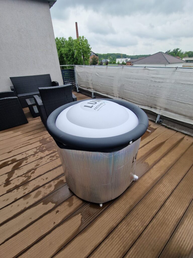 Lumi Eisbad mit UFO-Deckel und silberner Isoliermatte auf dem Balkon