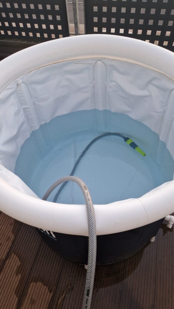 Gartenschlauch im leeren Lumi Eisbad beim Wasserwechsel